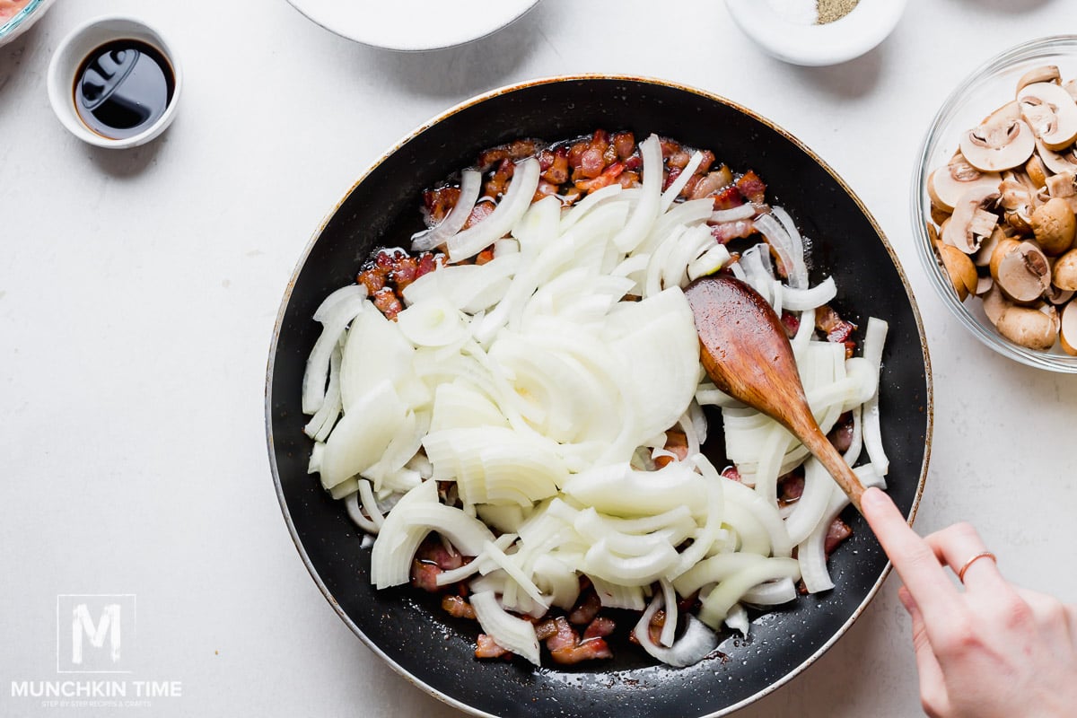 Onion added to the skillet with crispy bacon.