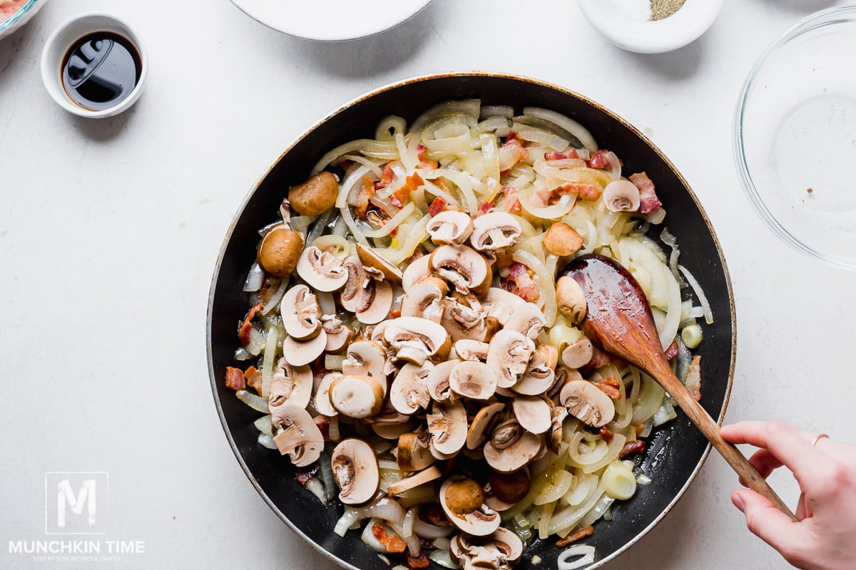 Mushrooms added to the skillet with onions and bacon.