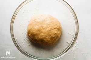 Dough is resting a oily bowl.