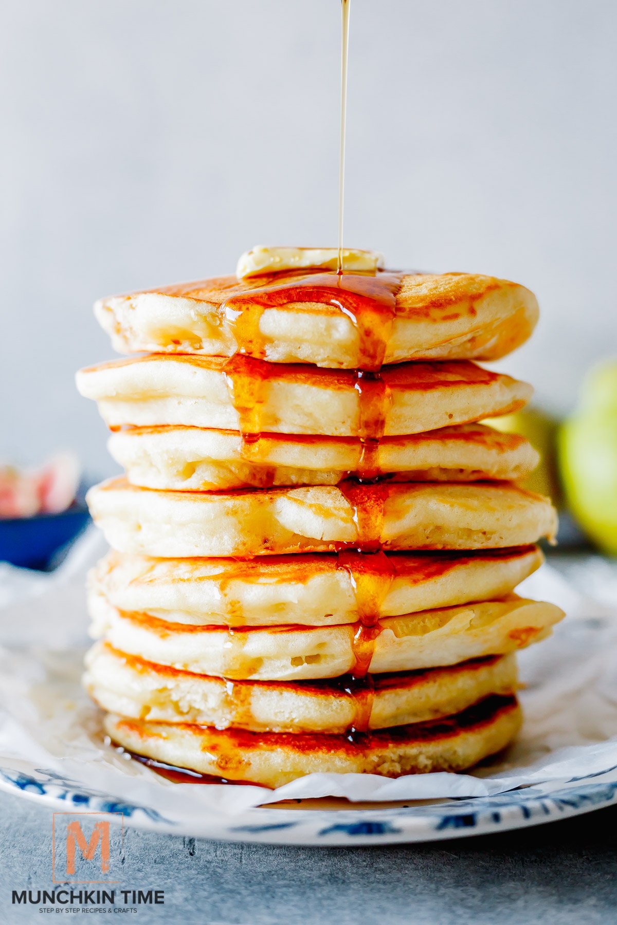 fluffy buttermilk pancakes and maple syrup being poured over the top.
