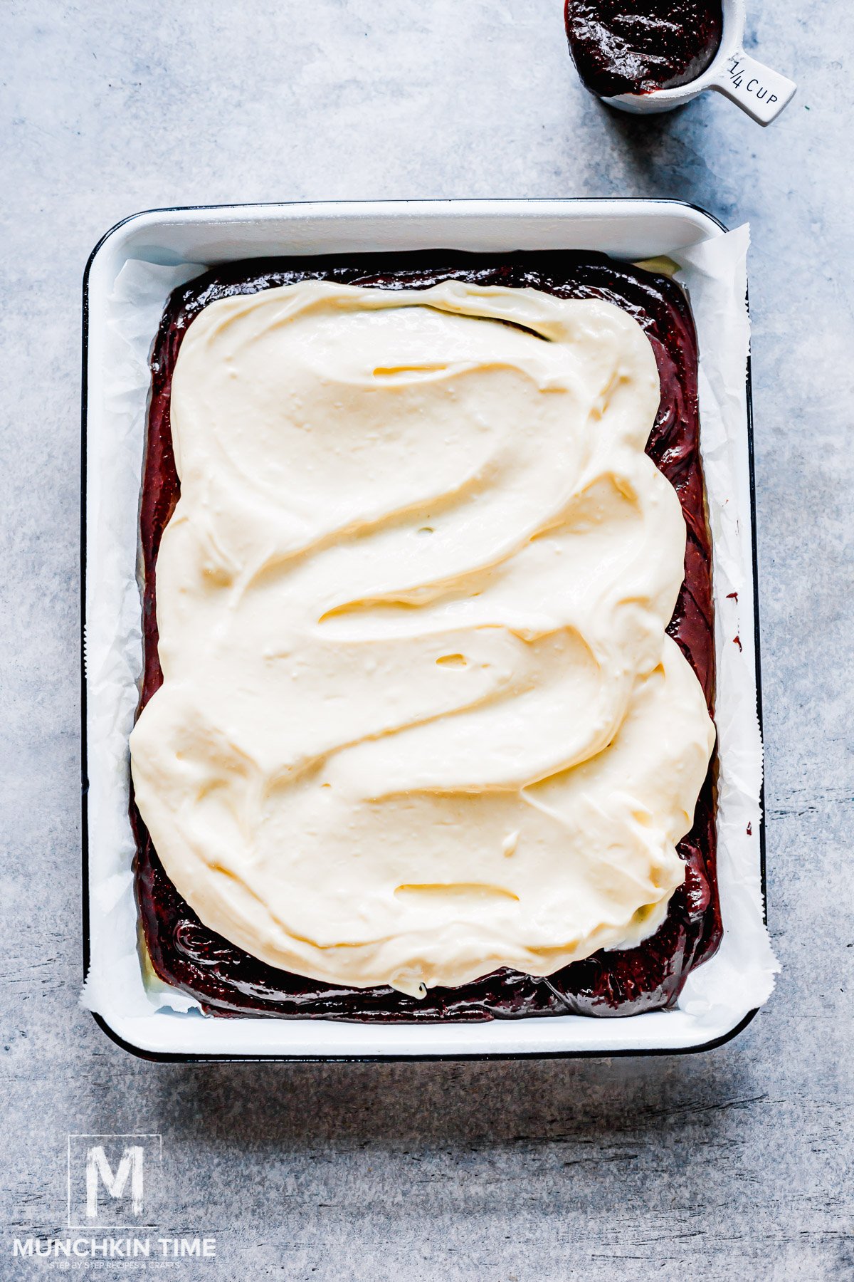 Cheesecake topping poured over the brownie dough.