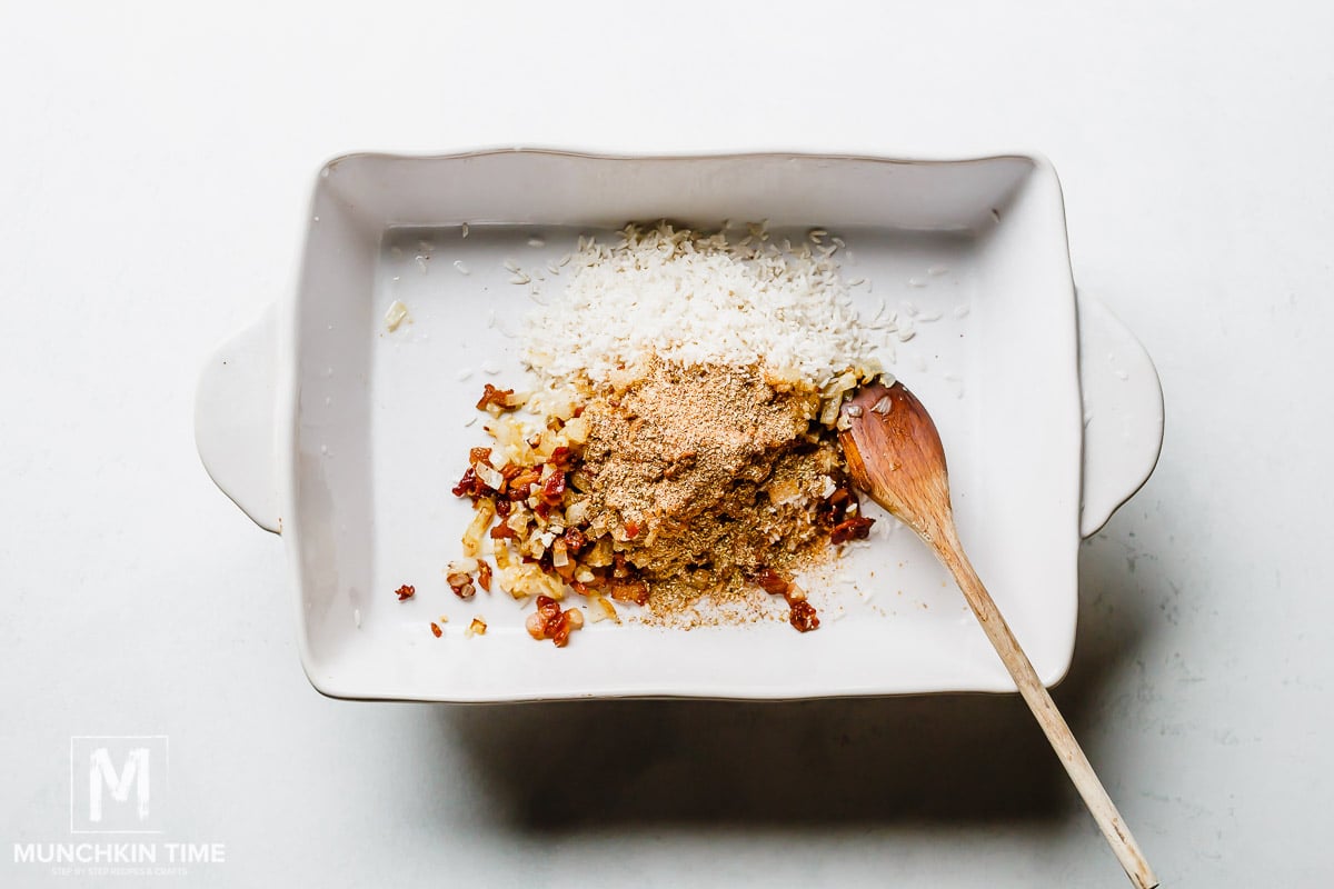 Half of the spice inside the casserole dish with rice.