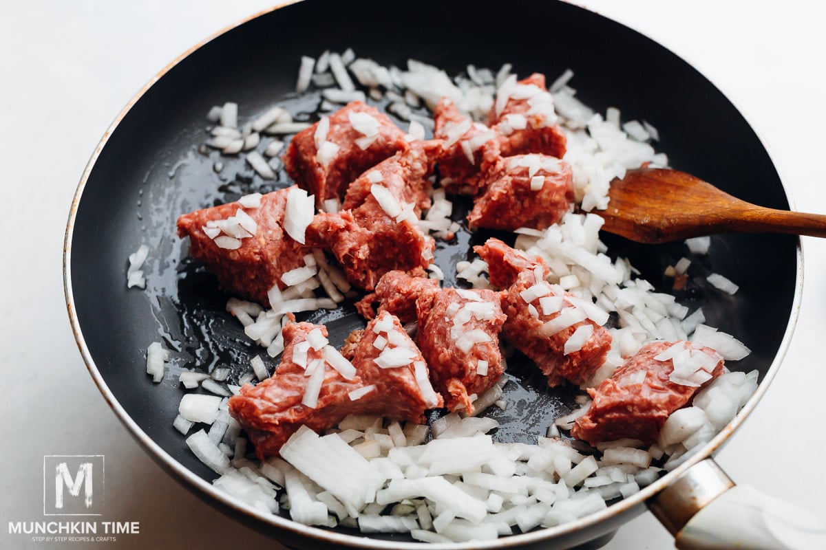 Ground beef and onion in the skillet.