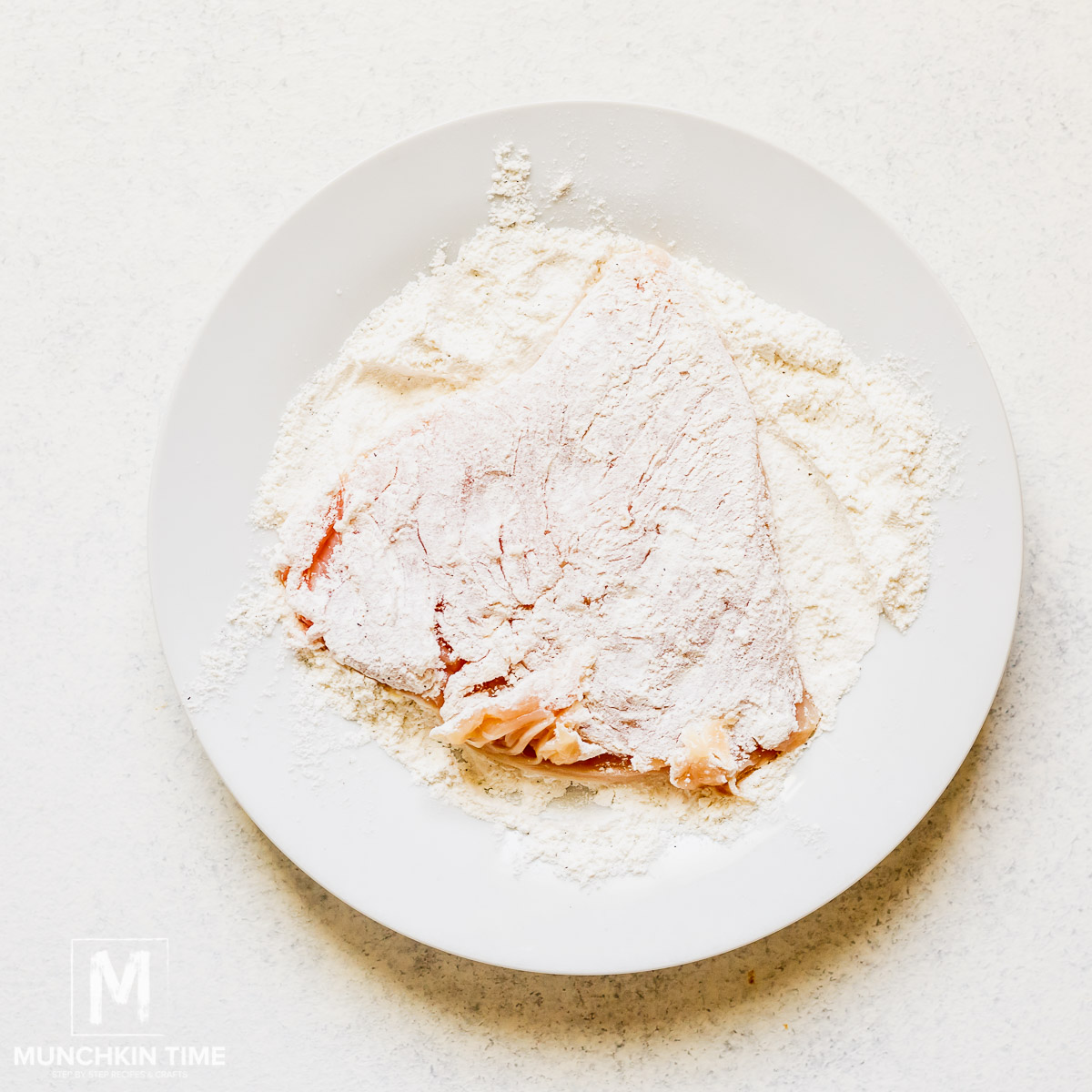 Pounded chicken breast dusted in flour.