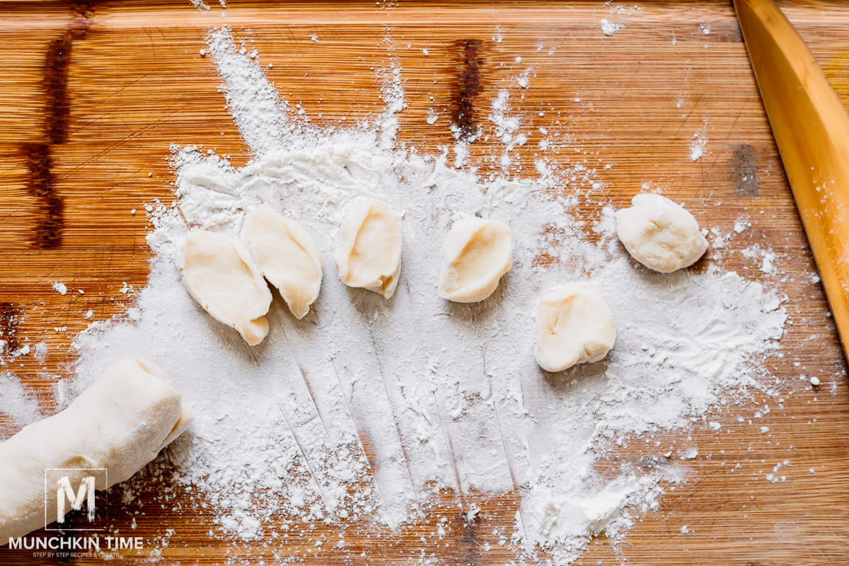 Rolling out and cutting dough for dumplings.