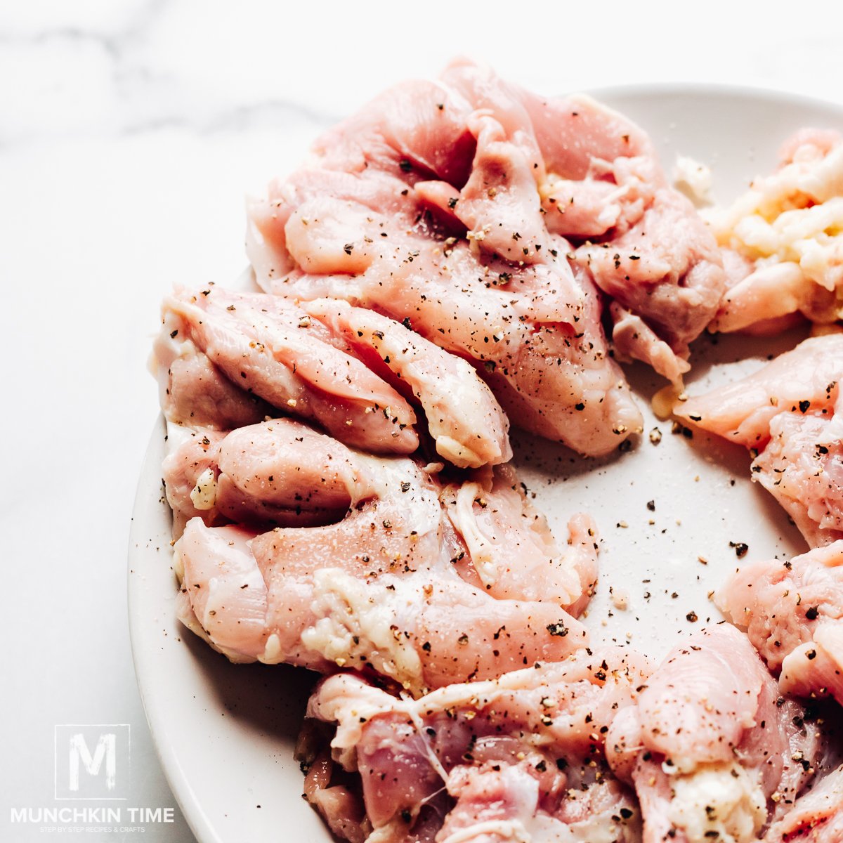 Chicken thighs seasoned with salt and pepper.