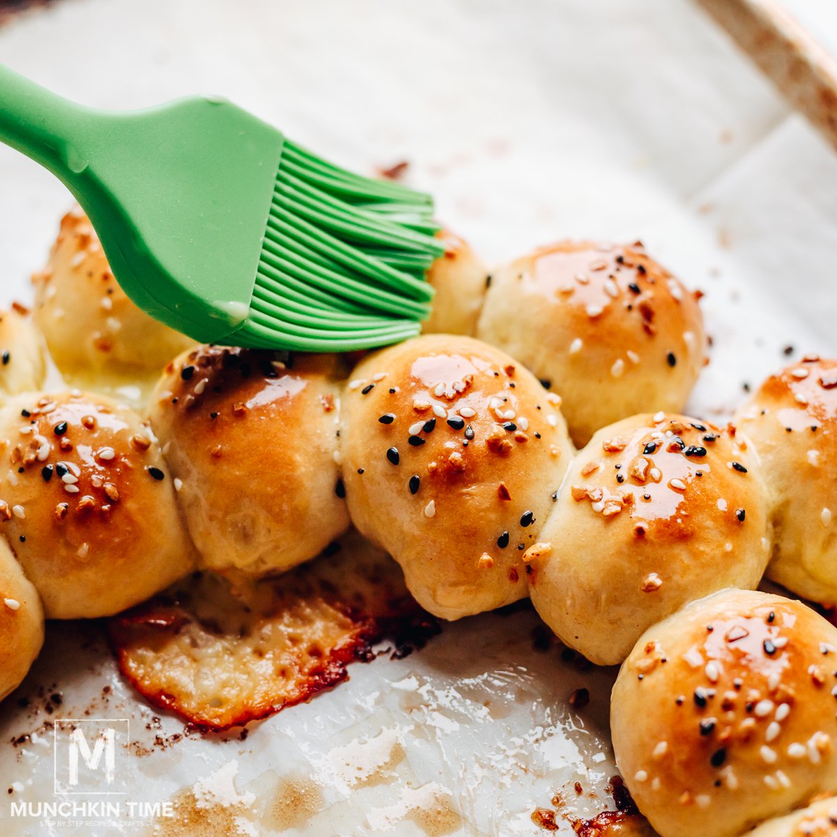 Melted butter brushed over baked pizza bites.