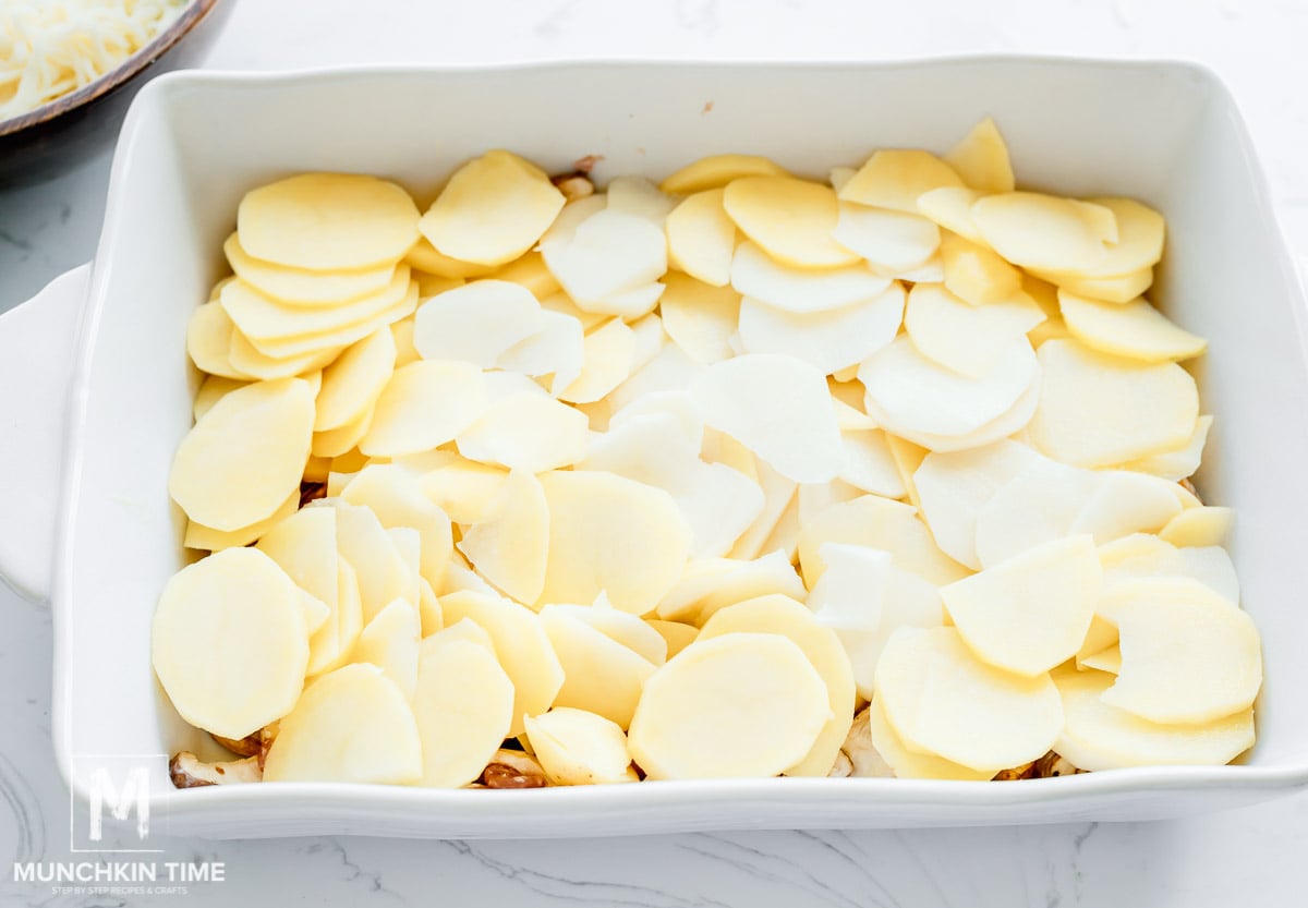 sliced potatoes over the chicken thighs