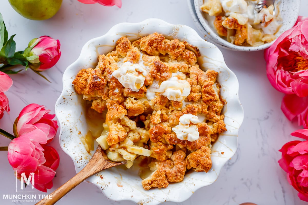 apple cobbler baked and ready to be eaten with ice cream scoops on top