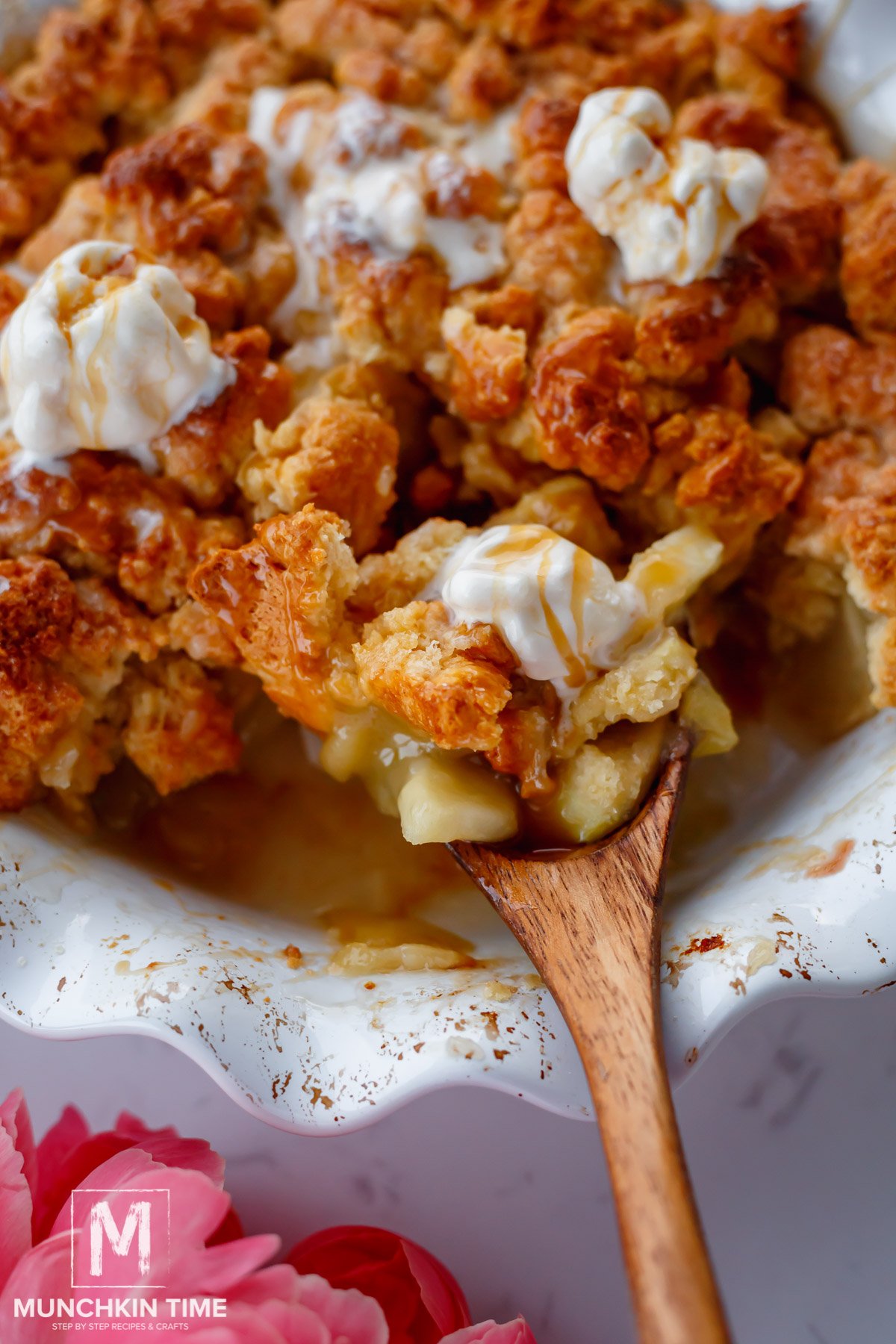 s wooden spoon filled with baked apple cobbler and ice cream topping
