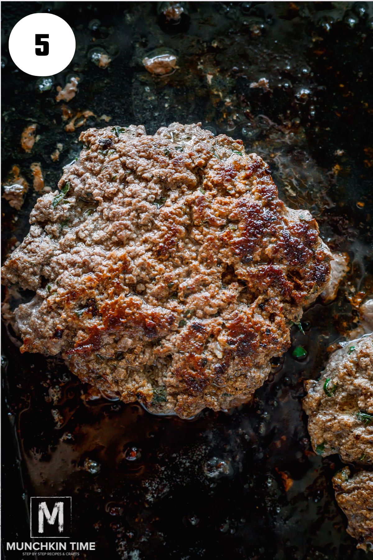 beef patty cooking on a griddle.