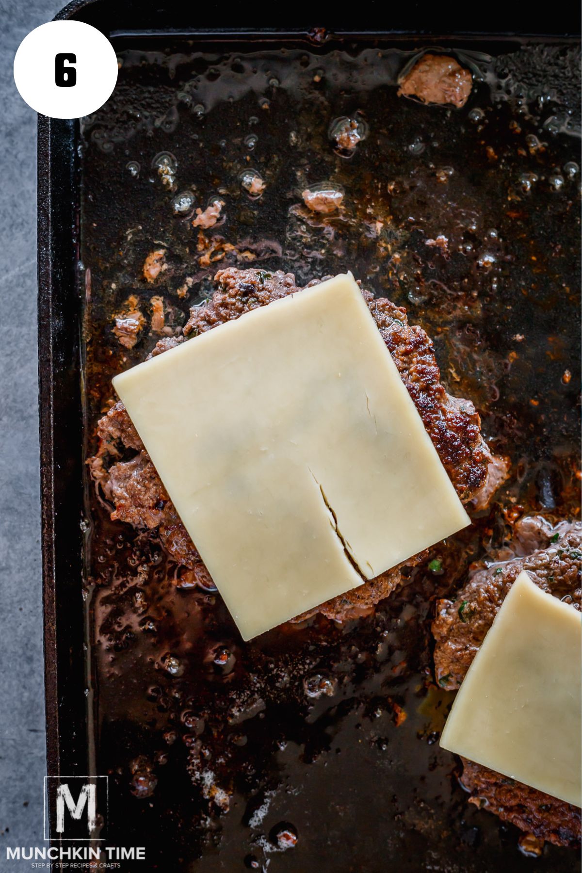sliced cheese added to the beef patty on the griddle.