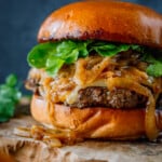 Caramelized Onions Burger with arugula on a platter.