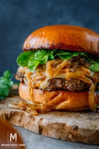 Caramelized Onions Burger with arugula on a platter.