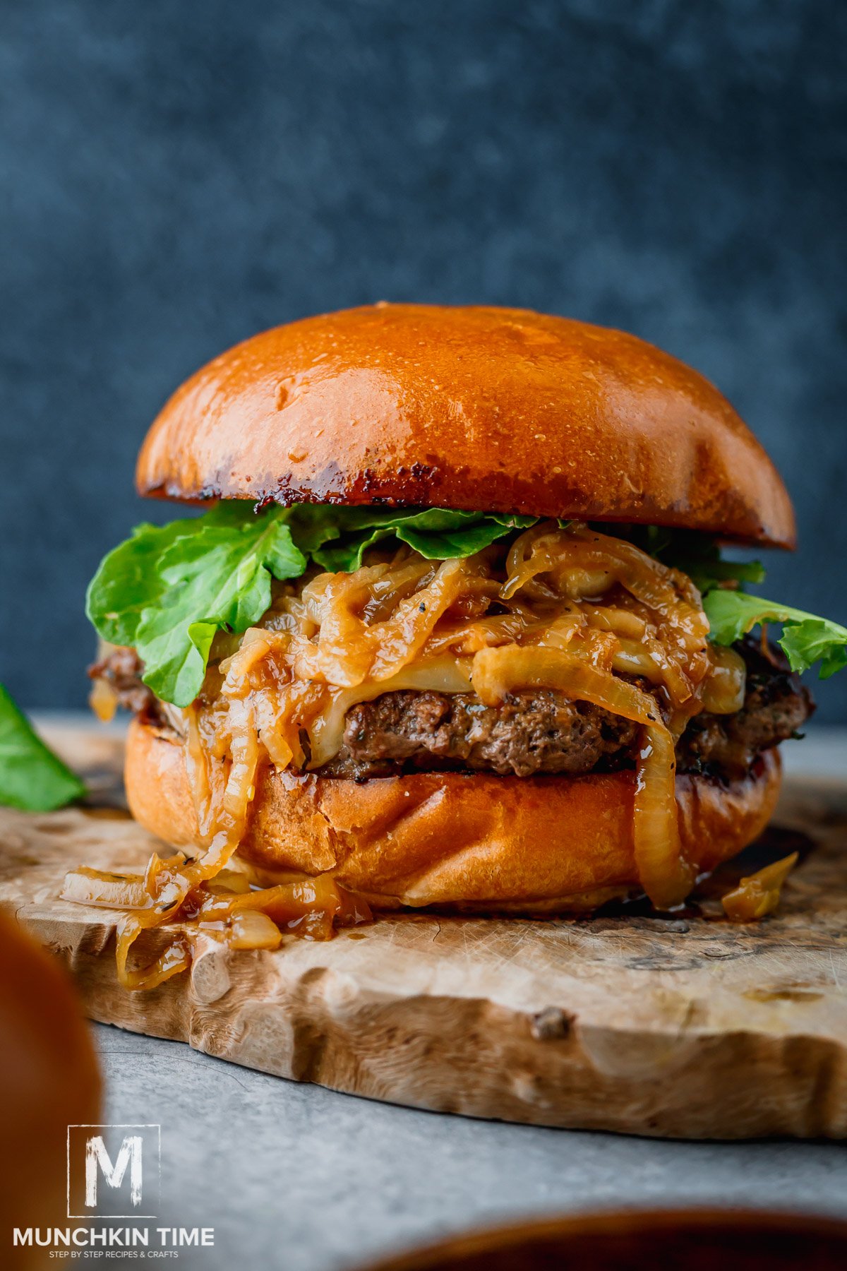 Caramelized Onions Burger with arugula on a platter.