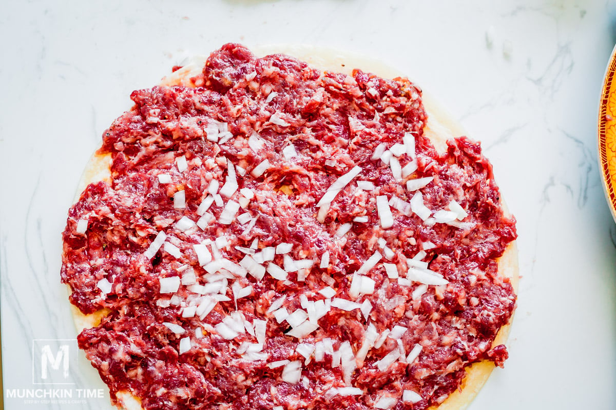 raw meat on top of tortilla