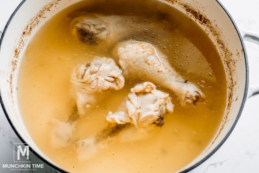 chicken broth and chicken drumsticks in the pot