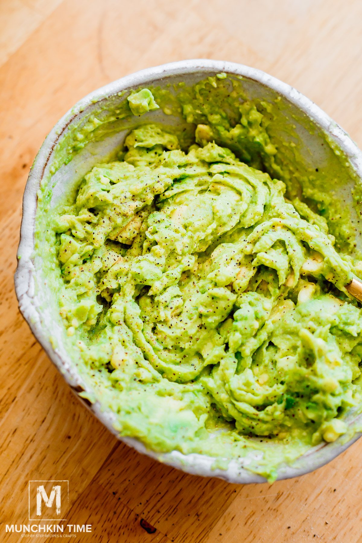 smashed avocado in a bowl with garlic and lemon juice