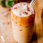 Protein Coffee with ice in a tall glass with glass straw.