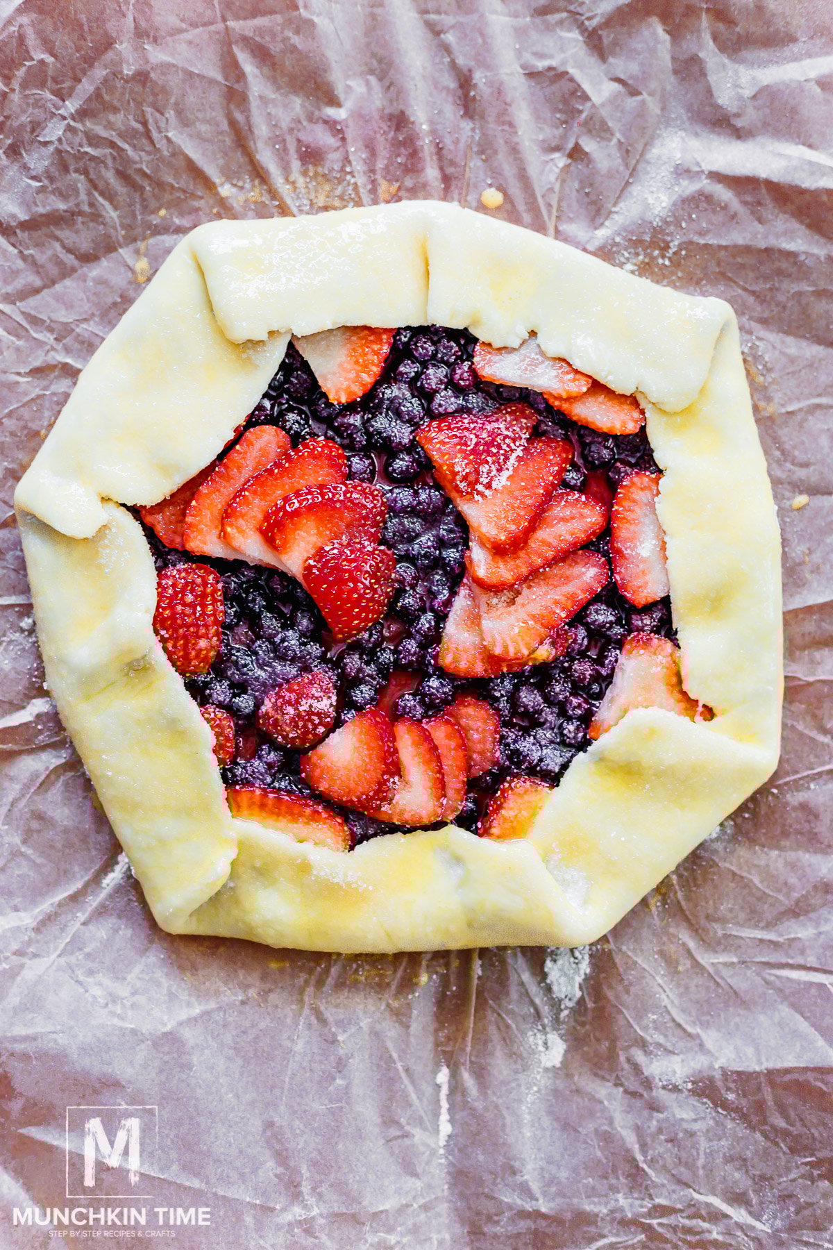 Egg wash brushed over unbaked strawberry galette.