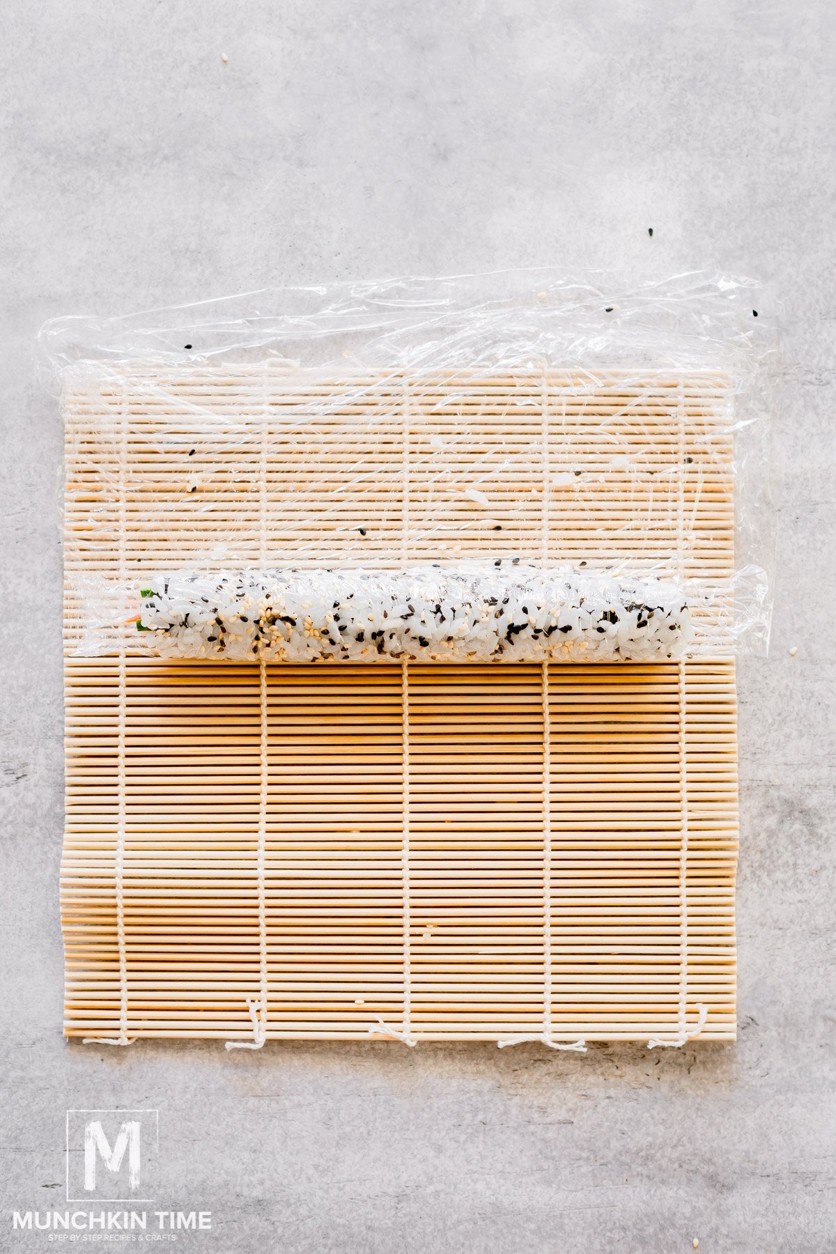 Nori sheet with filling and rice rolled up into a Philadelphia roll.
