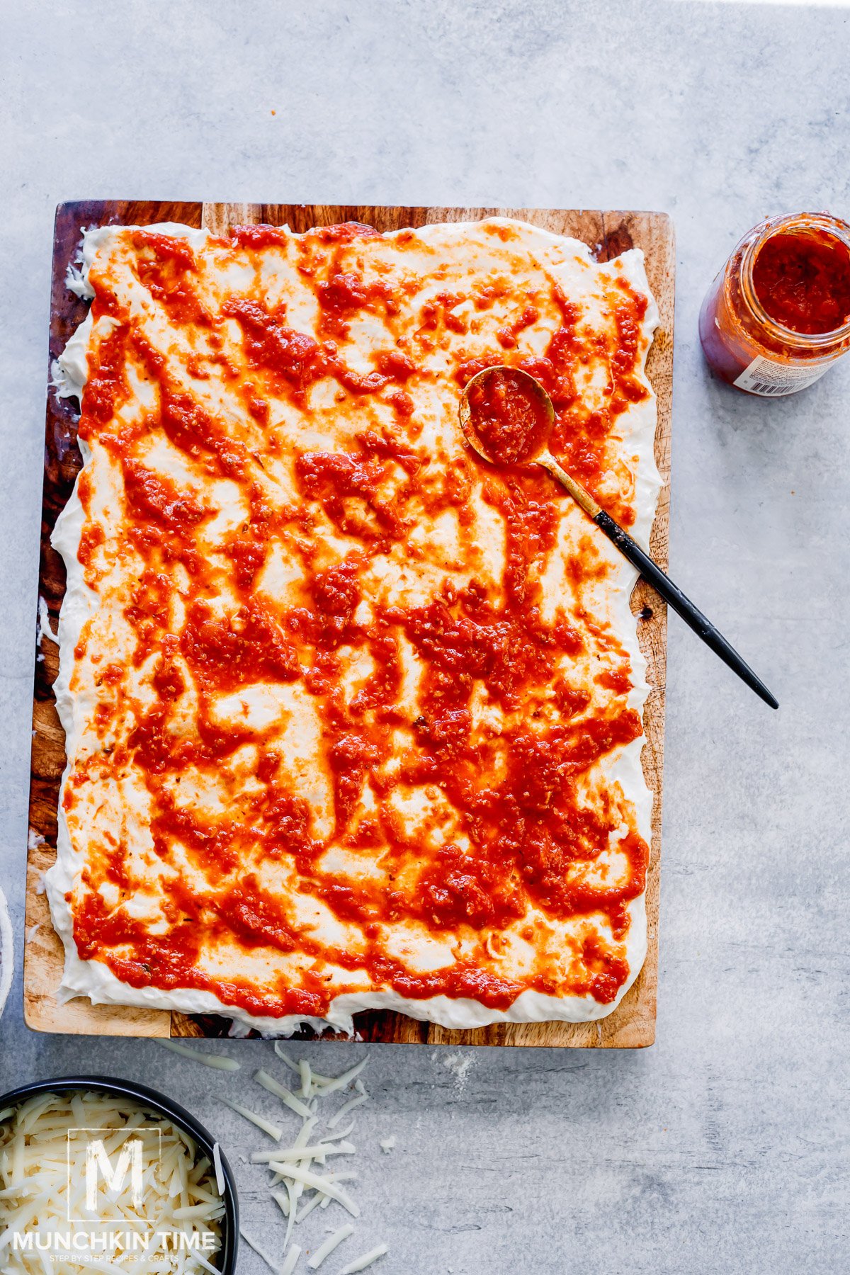 pizza sauce is spread over the sourdough dough.