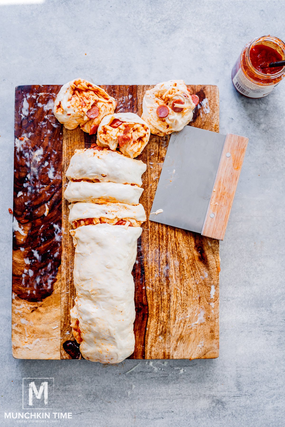the dough with filling rolled into a log and sliced into pizza rolls.