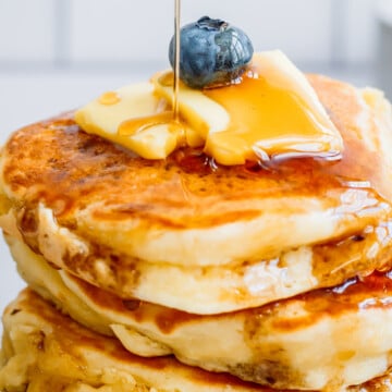 maple syrup pouring down a Sourdough Discard Pancake stack.