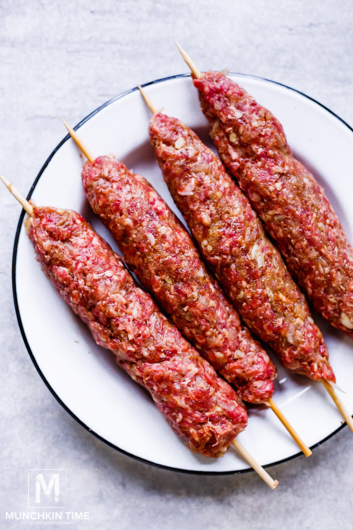 Ground beef mixture added to the bamboo skewers.