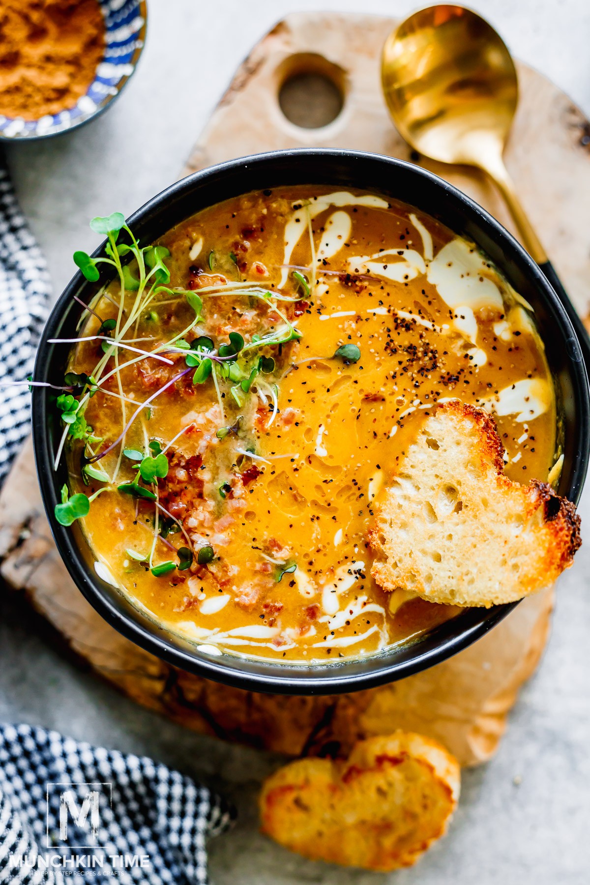 Creamy butternut squash soup topped with bacon and black pepper