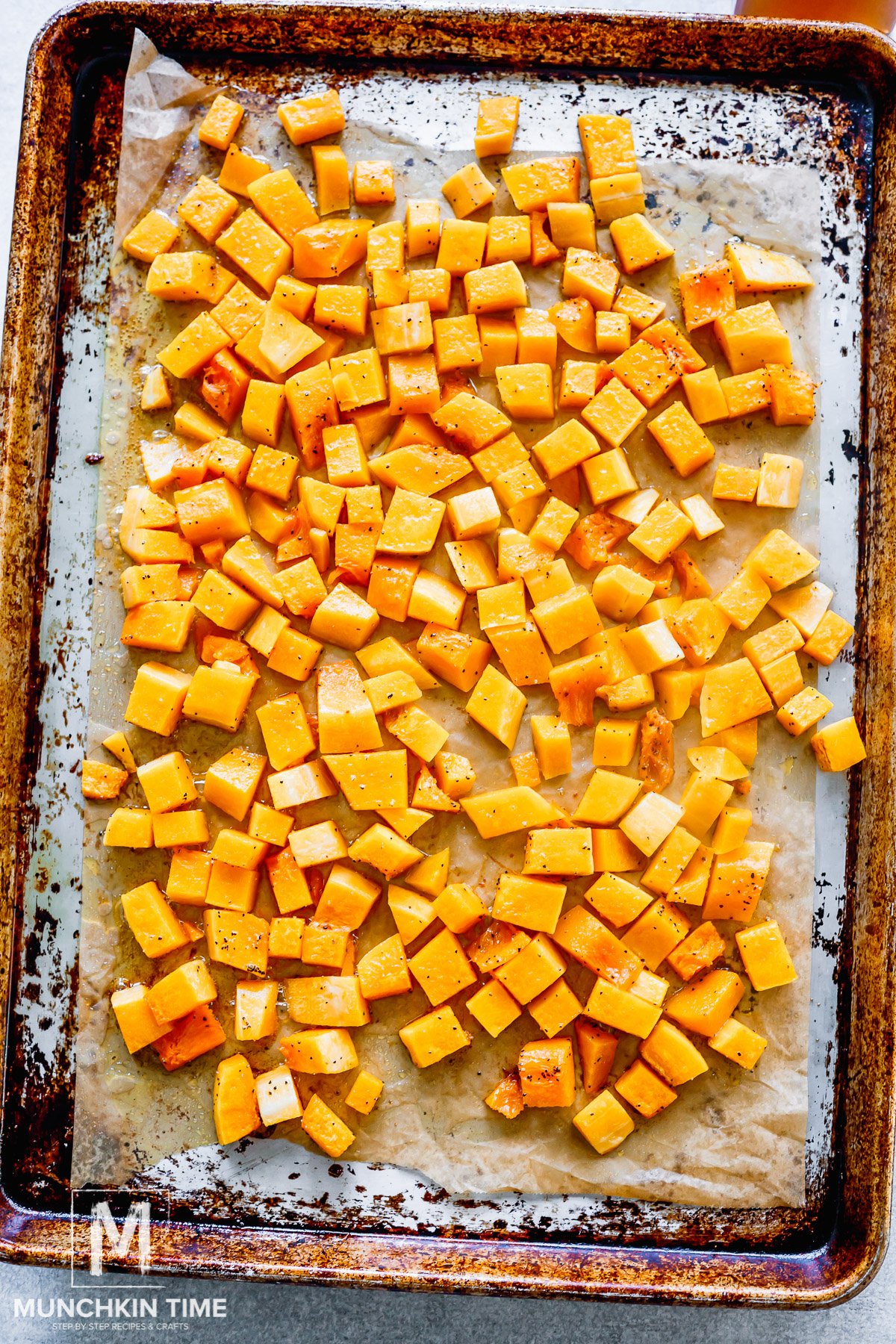 butternut squash cut into cubes and placed on a parchment paper.