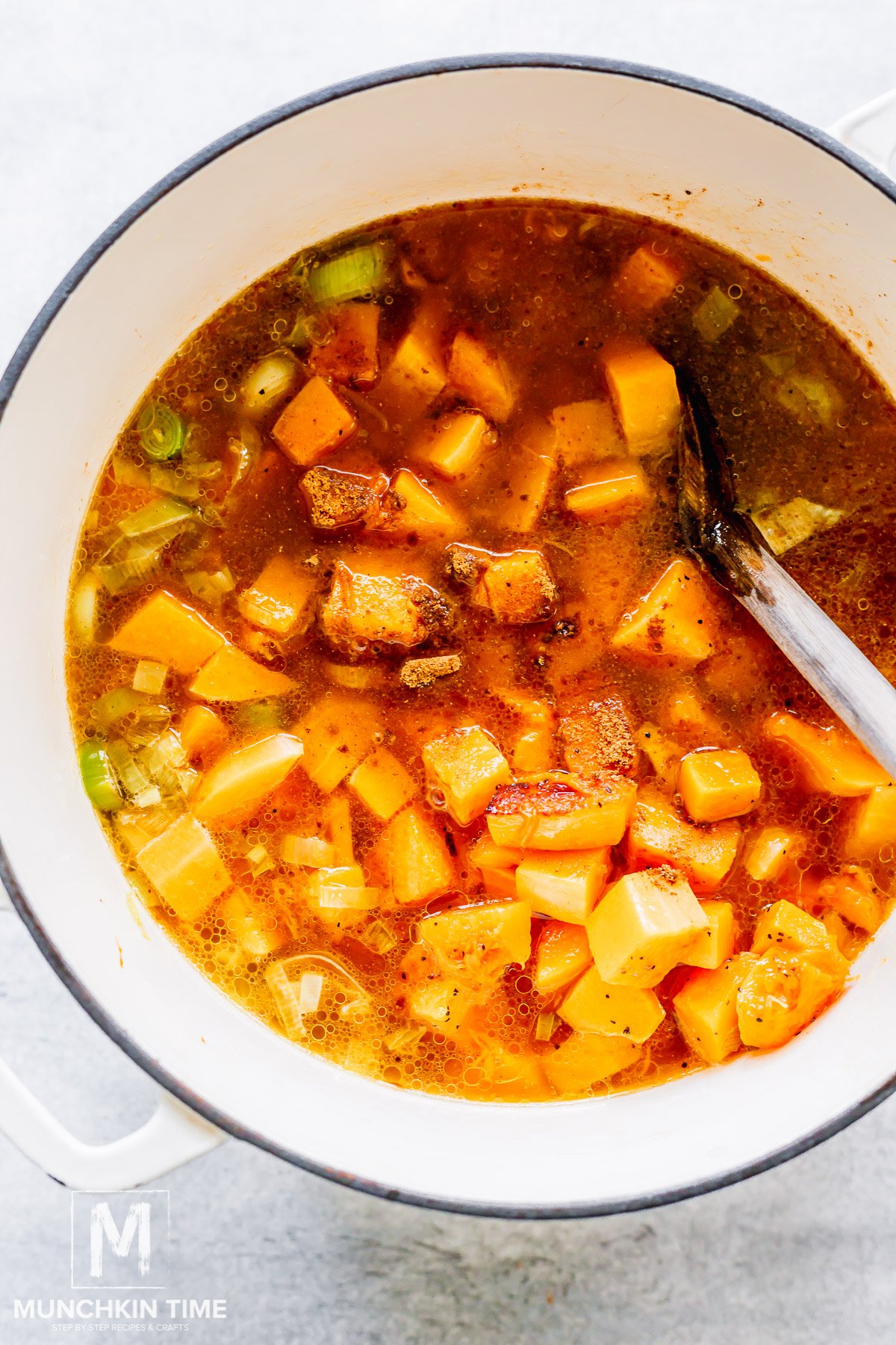 butternut squash added to the pot with spices and broth.