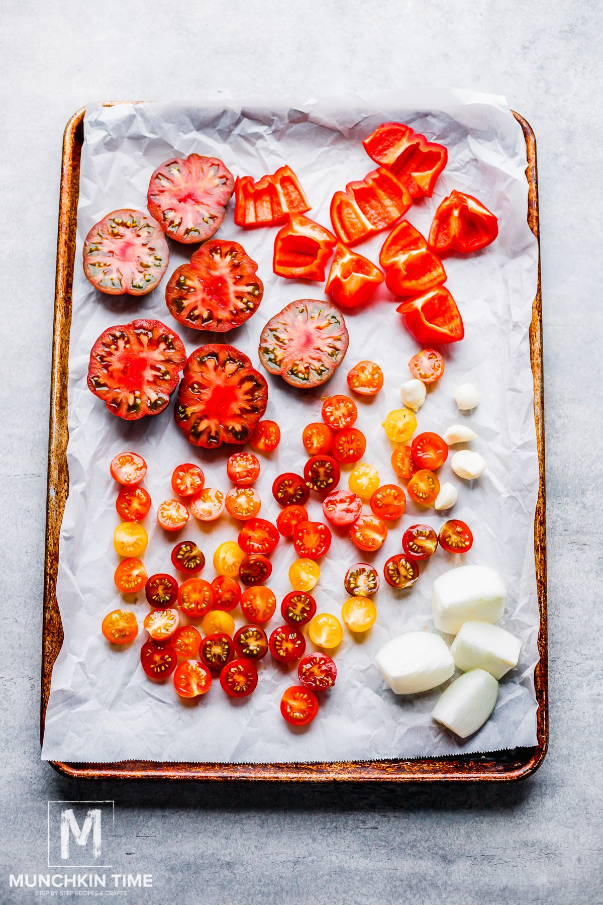 tomatoes sliced in half on a baking sheet ready for roasting.