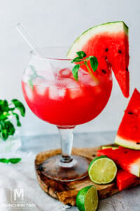 iced watermelon juice garnished with watermelon slice and basil.