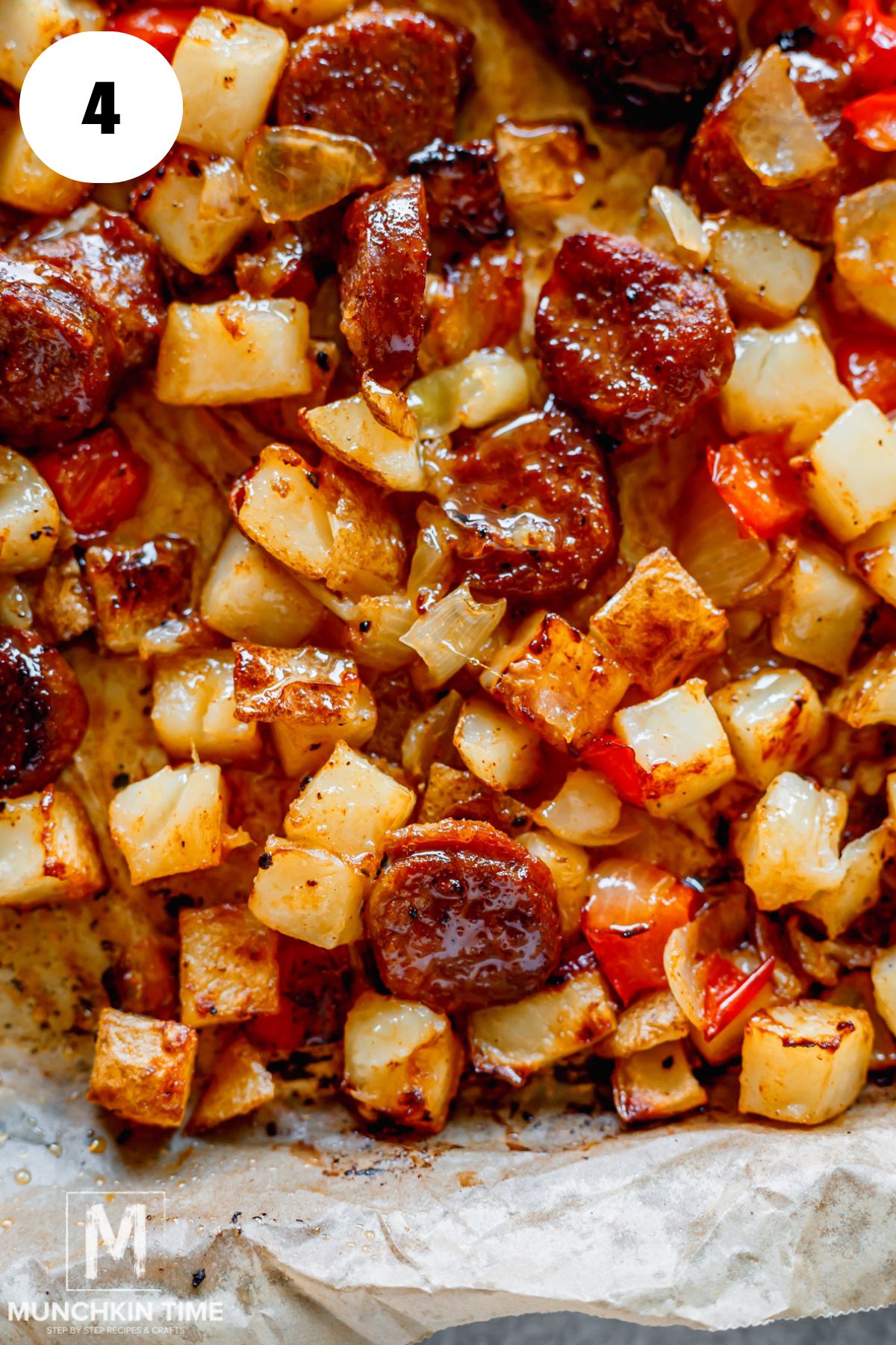 closer look at baked potatoes with sausages on a baking sheet.