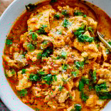 creamy chicken tikka masala in a bowl garnished with cilantro.
