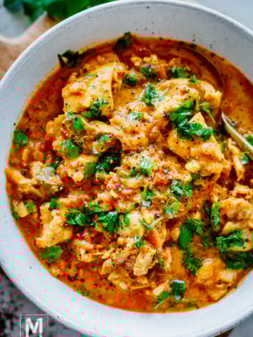 creamy chicken tikka masala in a bowl garnished with cilantro.