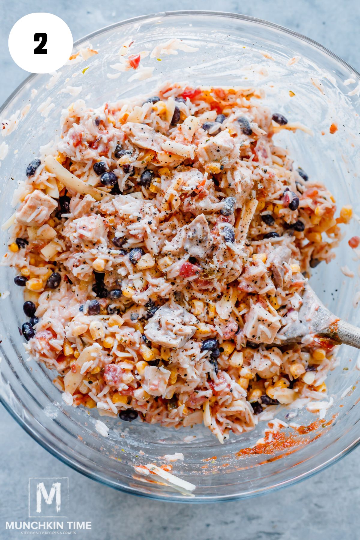 In a large mixing bowl, combine the chicken, rice, beans, corn, tomatoes, salsa, sour cream, and cheddar cheese.