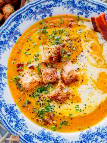 Creamy Carrot Soup garnish with croutons chives and cream.