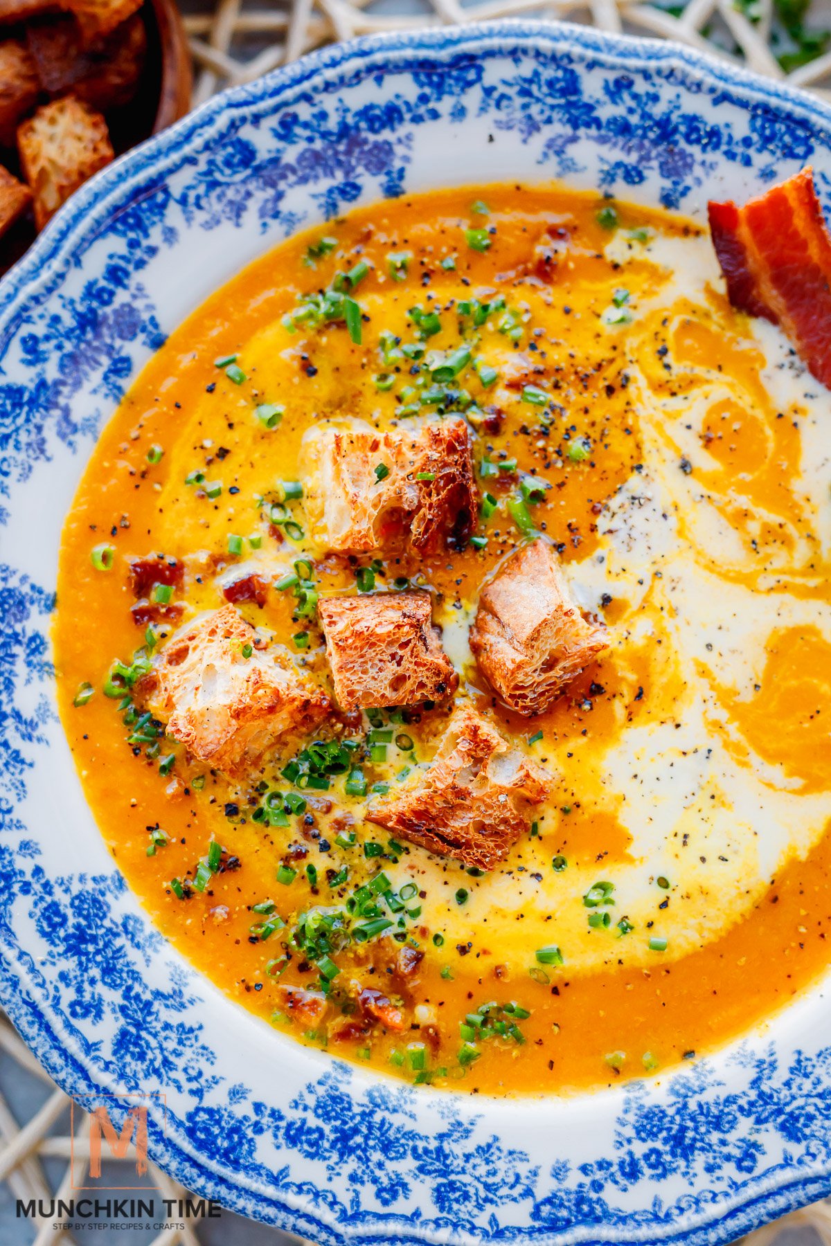 Creamy Carrot Soup garnish with croutons chives and cream.