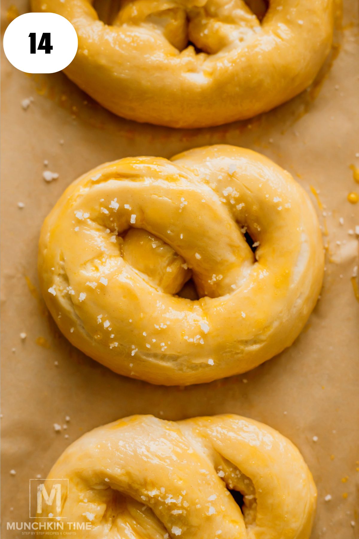 pretzel on a baking sheet with egg wash and sea salt.
