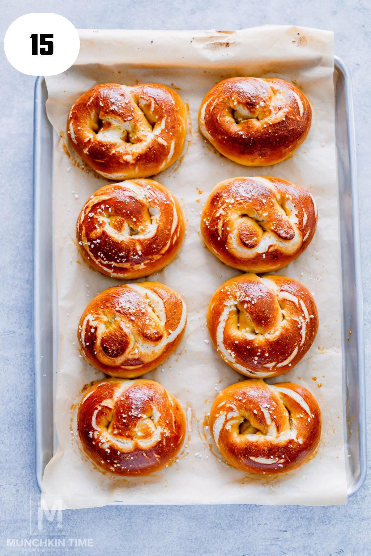8 pretzels done baking on a baking sheet.