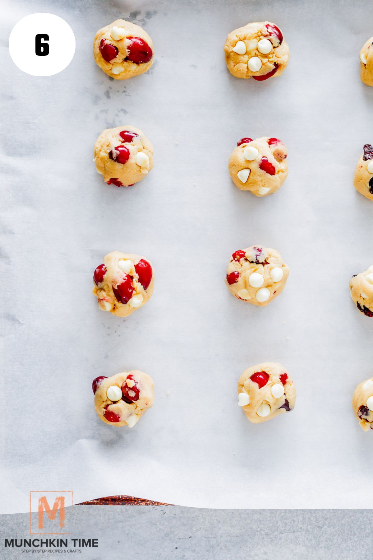 cranberry cookie balls with fresh cranberries on a baking sheet ready for baking.