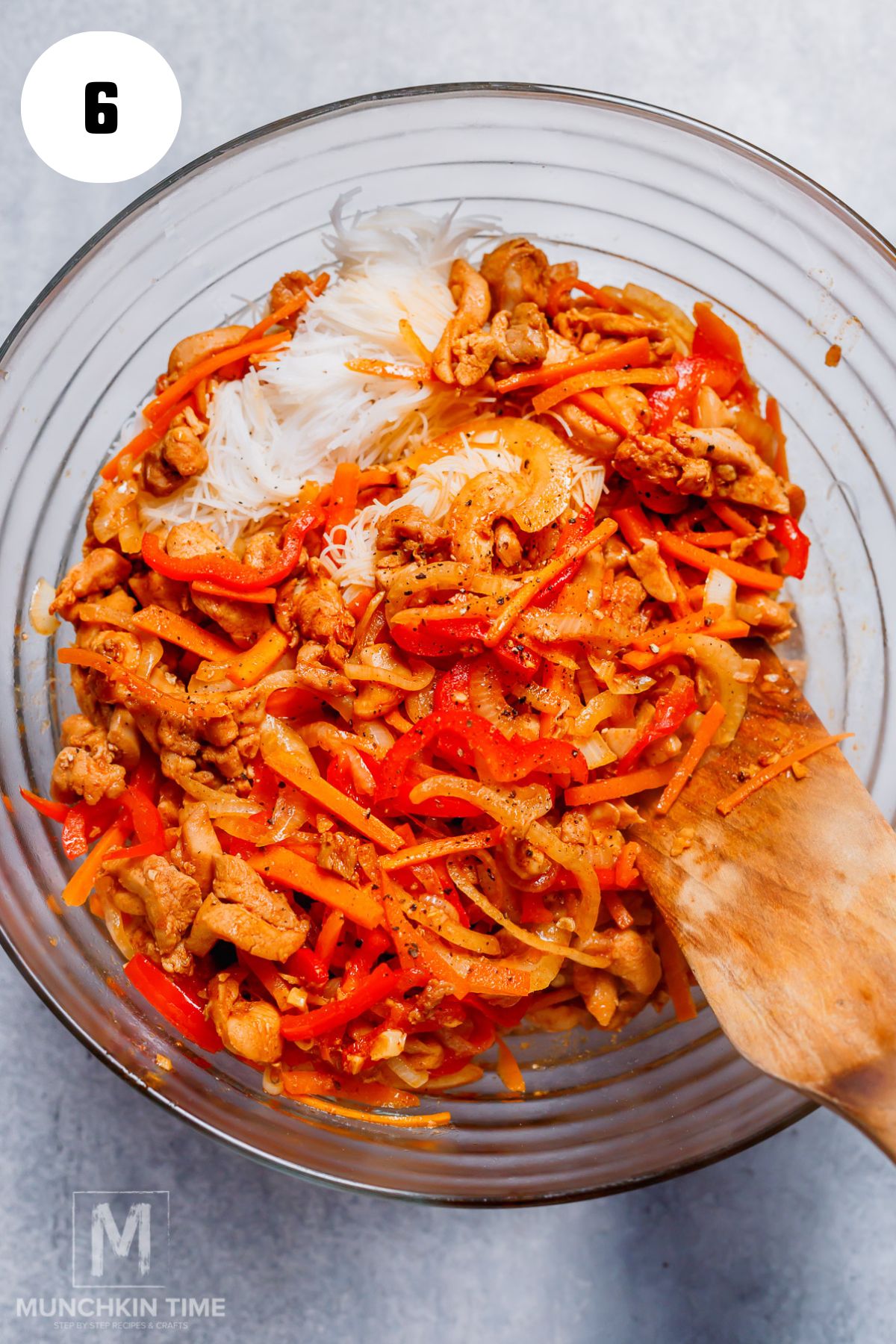 stir fry chicken and veggies added to the bowl with glass noodles.