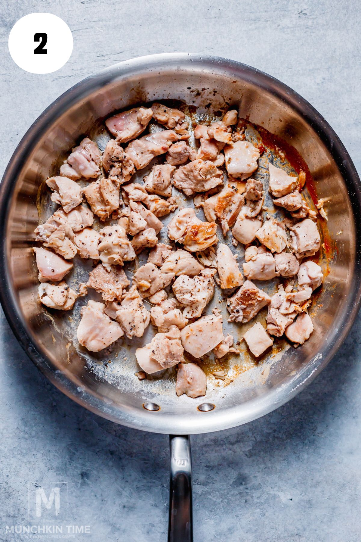 chicken thighs pieces cooking in the skillet.