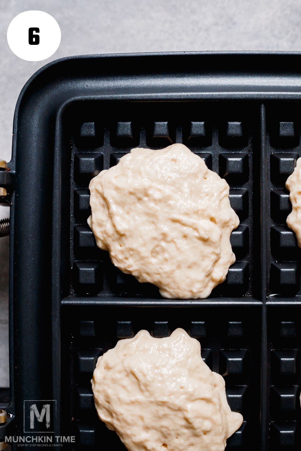 cooking the Fluffy Sourdough Waffles batter in the waffle maker.