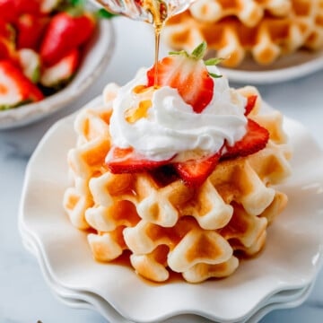 Maple syrup pouring over the Crispy Sourdough Waffles (Easy Discard or Active Starter Recipe)