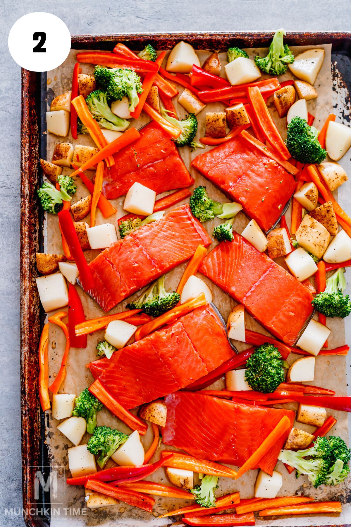salmon fillet placed on parchment paper with veggies.