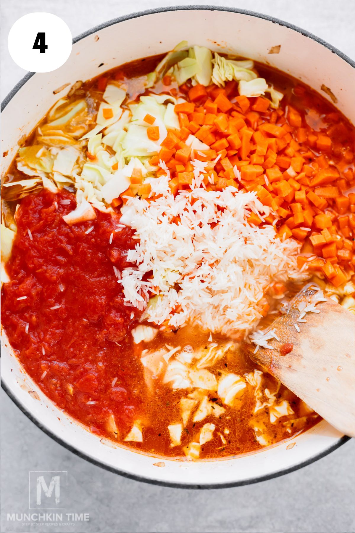 broth, tomatoes, carrots, cabbage, and rice added to the soup.