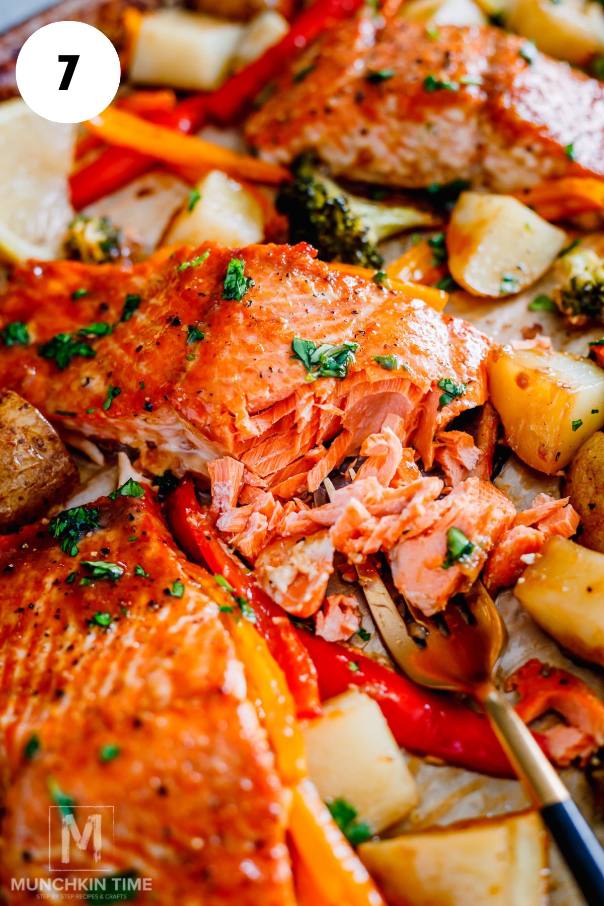 flakey salmon after baking in the oven with veggies.